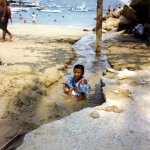 Niño jugando en una descarga de aguas residuales